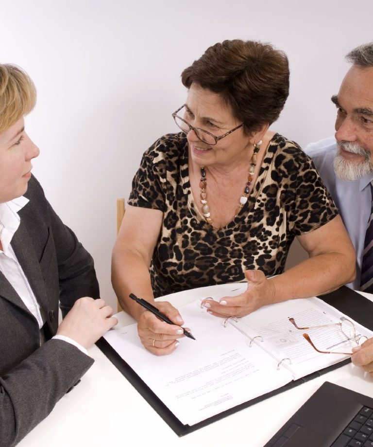 Pareja mayor firmando con una gestora